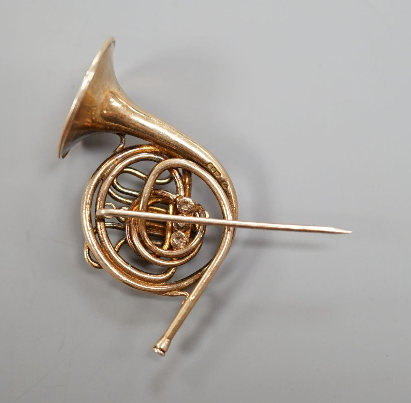 A modern silver gilt brooch, modelled as a French horn, maker, JC, London, 1981, 30mm.